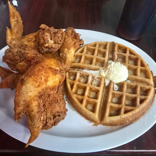 Noonie's Place soul food: crispy fried chicken wings and a waffle with melting butter.