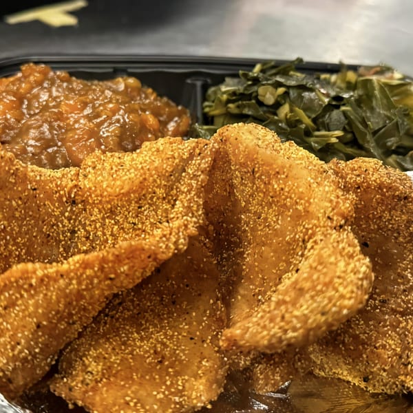 Noonie's Place soul food meal with crispy fried fish, collard greens, and candied yams.