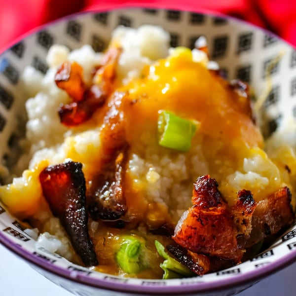 Noonie’s Place soul food dish with rice, yellow sauce, crispy bacon, and green onions.